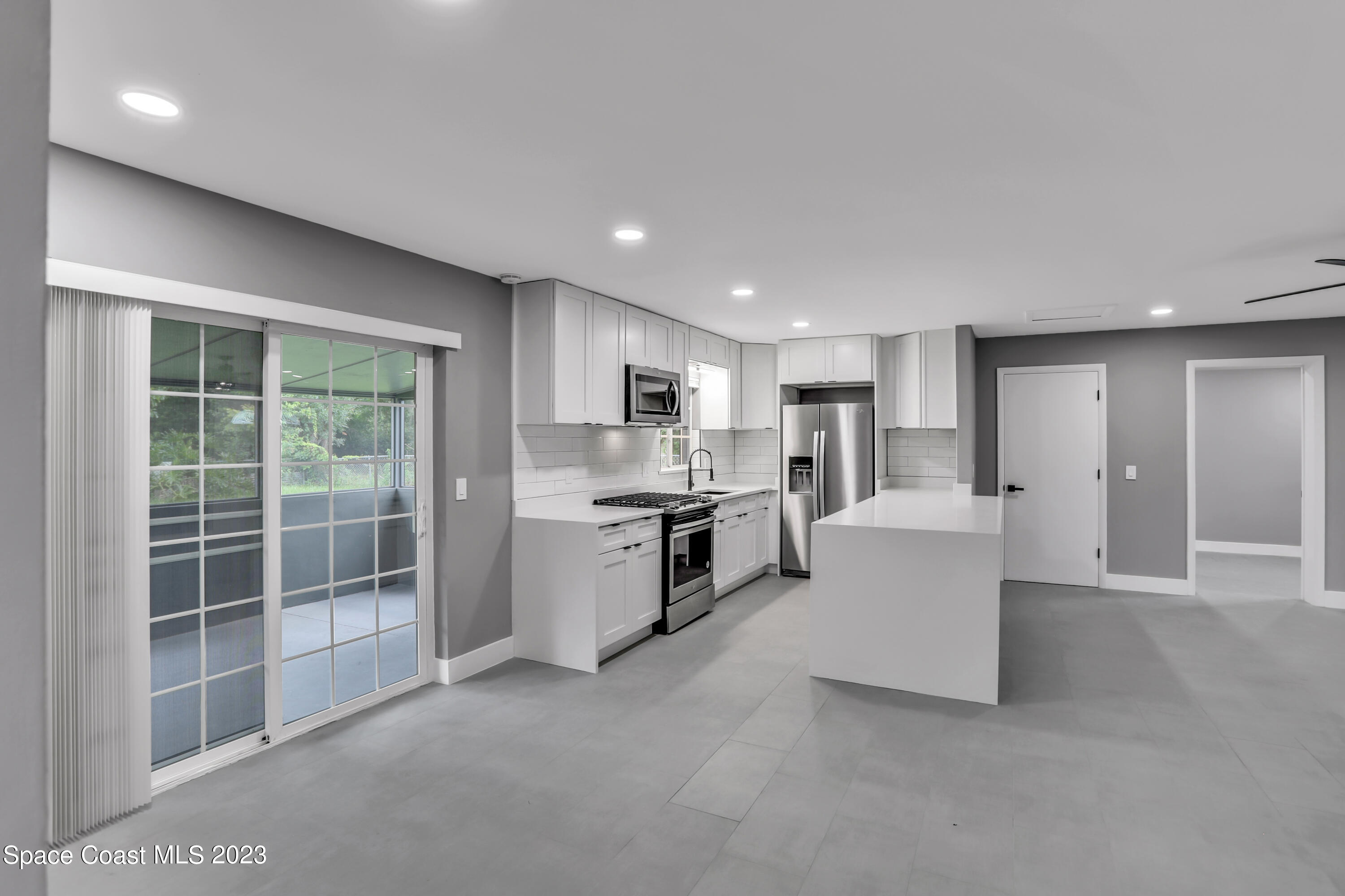 1905 Exeter Drive Cocoa, FL 32922 - Photo 10 of 37 a large white kitchen with kitchen island a sink a counter top space and stainless steel appliances