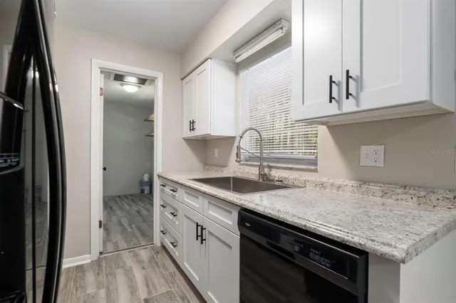 a kitchen with granite countertop a sink stove and refrigerator