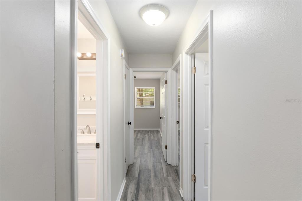 605 Northwest 9th Circle Williston, FL 32696 - Photo 6 of 11 a view of a hallway with wooden floor and a bathroom