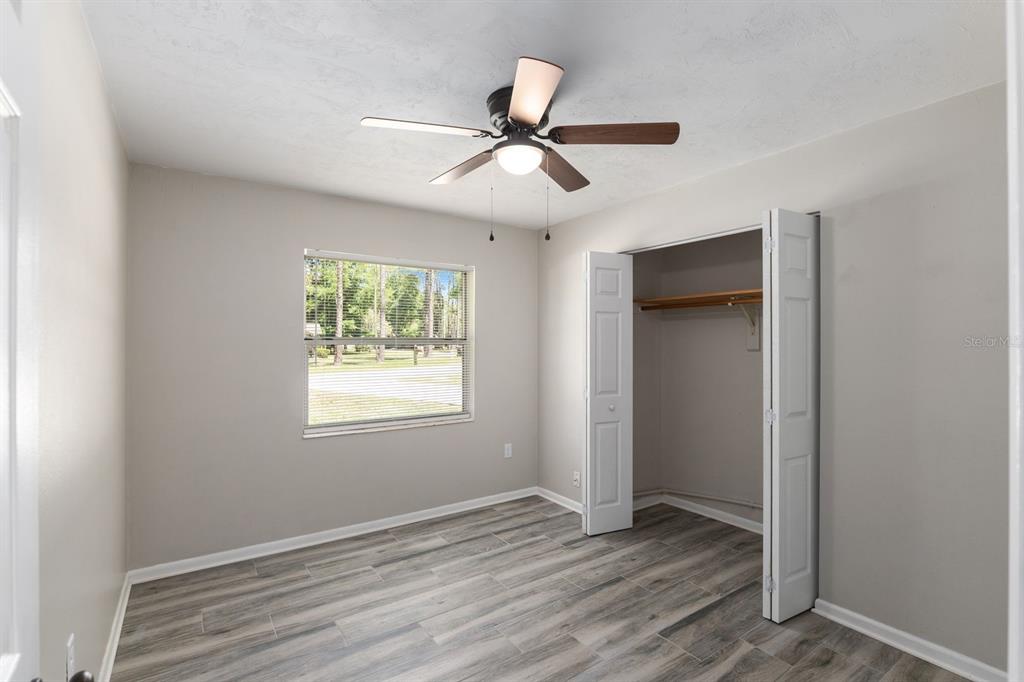 605 Northwest 9th Circle Williston, FL 32696 - Photo 7 of 11 a view of an empty room with wooden floor and a window