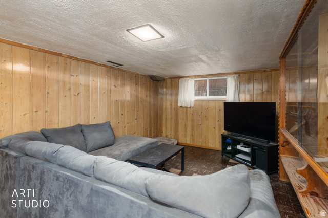 875 Patterson Street Ogden, UT 84403 - Photo 25 of 38 Living area featuring wood walls and a textured ceiling