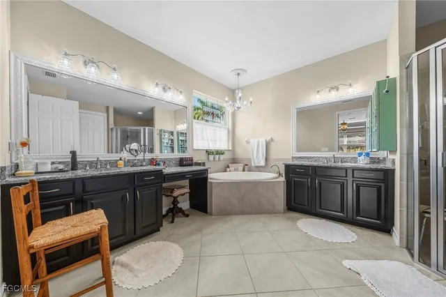a bathroom with a granite countertop tub sink shower and mirror