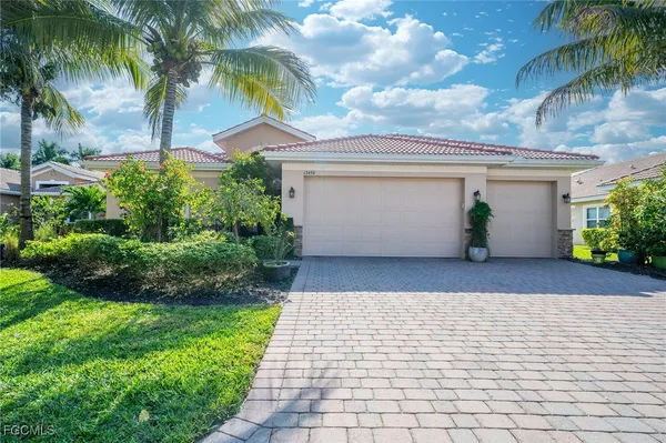 a palm tree sitting in front of a house with a yard