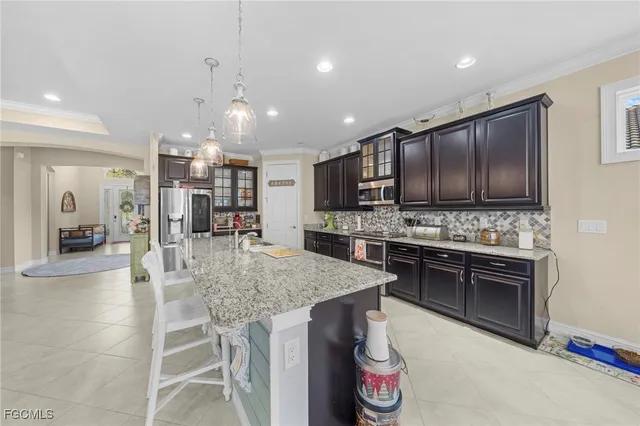 a kitchen with kitchen island granite countertop stainless steel appliances and a view of living room