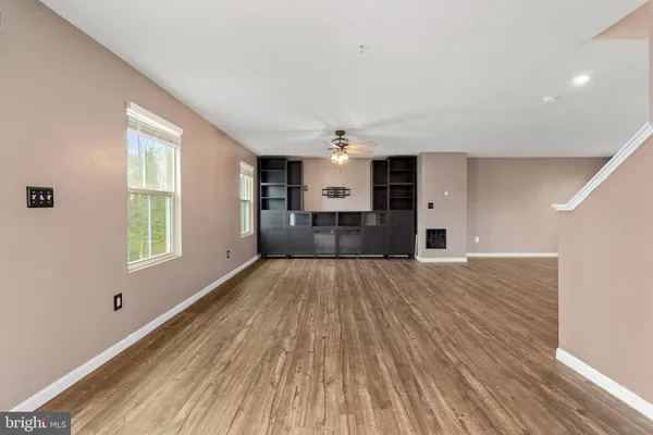 a view of empty room with wooden floor and window