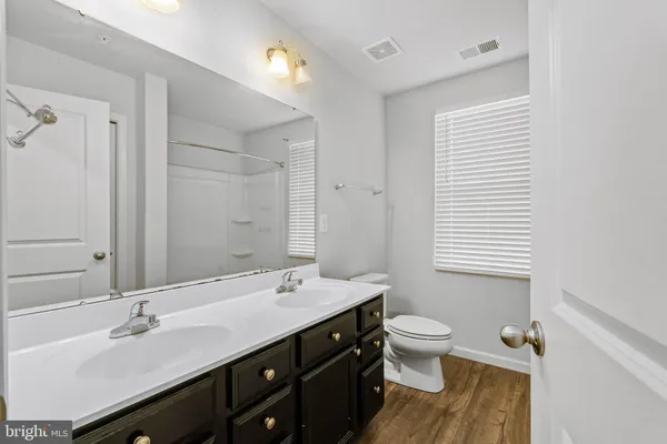 a bathroom with a double vanity sink toilet and a mirror