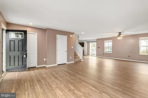 a view of a livingroom with wooden floor and staircase