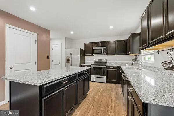 a kitchen with stainless steel appliances granite countertop a sink stove microwave and cabinets