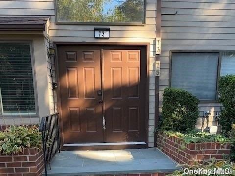 75 The Circle, Unit 75 Glen Head, NY 11545 - Photo 1 of 1 a front view of a house with a glass door