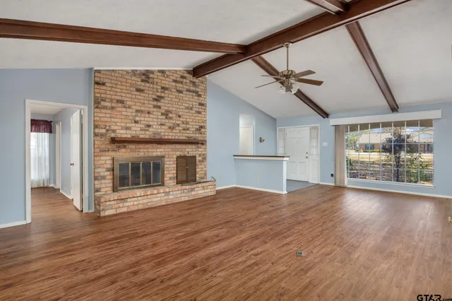 a view of empty room with wooden floor and fireplace
