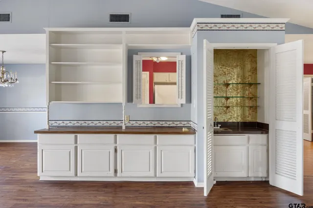 a kitchen with white cabinets and a wooden floor