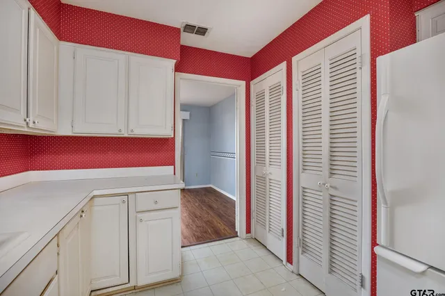 a kitchen with a refrigerator sink and cabinets