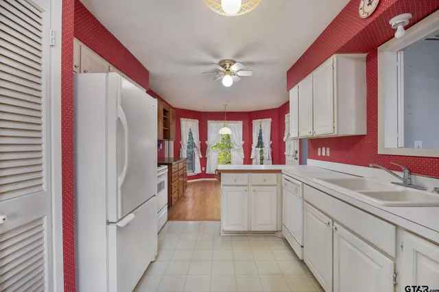 a kitchen with granite countertop a sink and a dishwasher a cabinets with wooden floor