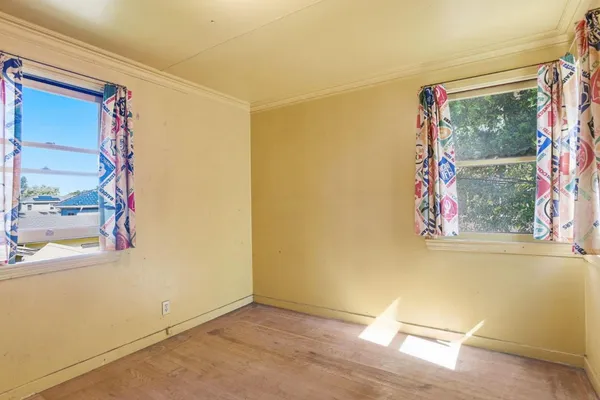 a view of a small space with wooden floor and a window