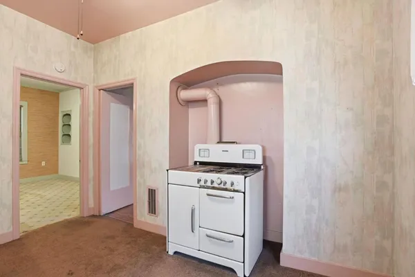 a kitchen with a stove a sink and a window