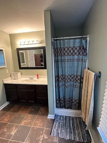 a view of en suite bathroom with a sink and a mirror