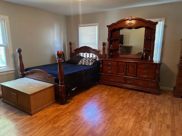a bedroom with a bed and a mirror on dresser