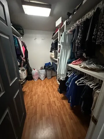 a view of walk in closet with clothes and shoes