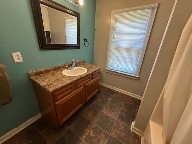 a bathroom with a granite countertop sink and a mirror