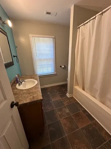 a bathroom with a granite countertop sink and a mirror