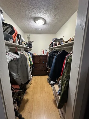 a view of walk in closet with clothes and shoes