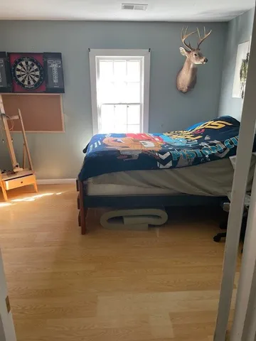 a bedroom with a bed and a lamp on the dresser