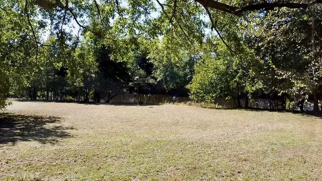 a view of a house with backyard and trees