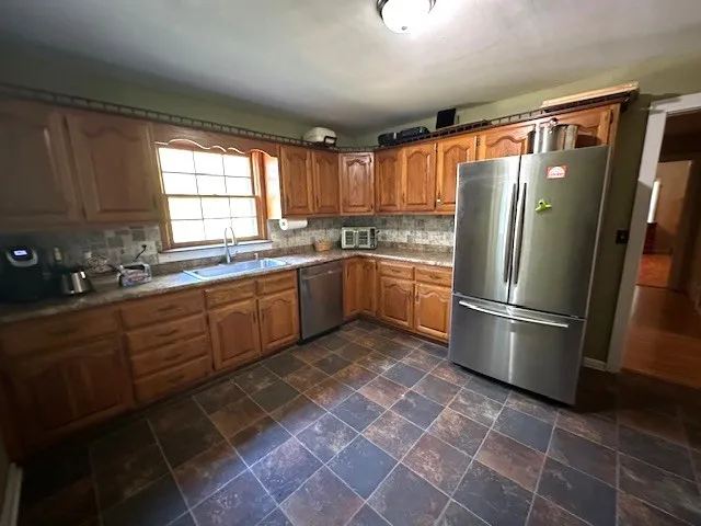 a kitchen with stainless steel appliances granite countertop a refrigerator sink and cabinets