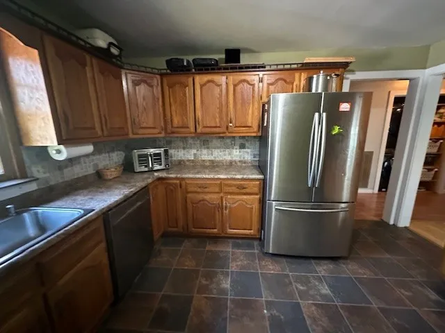 a kitchen with a refrigerator a sink and cabinets