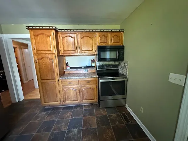 a kitchen with a refrigerator stove and microwave