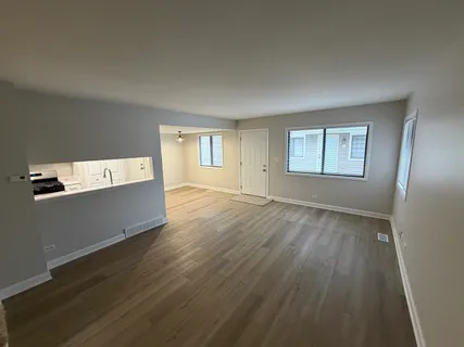 a view of a room with wooden floor and window