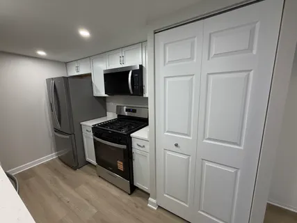 a kitchen with stainless steel appliances a refrigerator a stove a microwave and cabinets