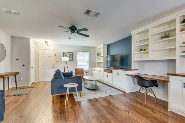 a living room with furniture a flat screen tv and kitchen view
