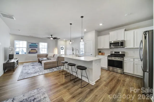 a large kitchen with stainless steel appliances granite countertop a lot of counter space and wooden floor