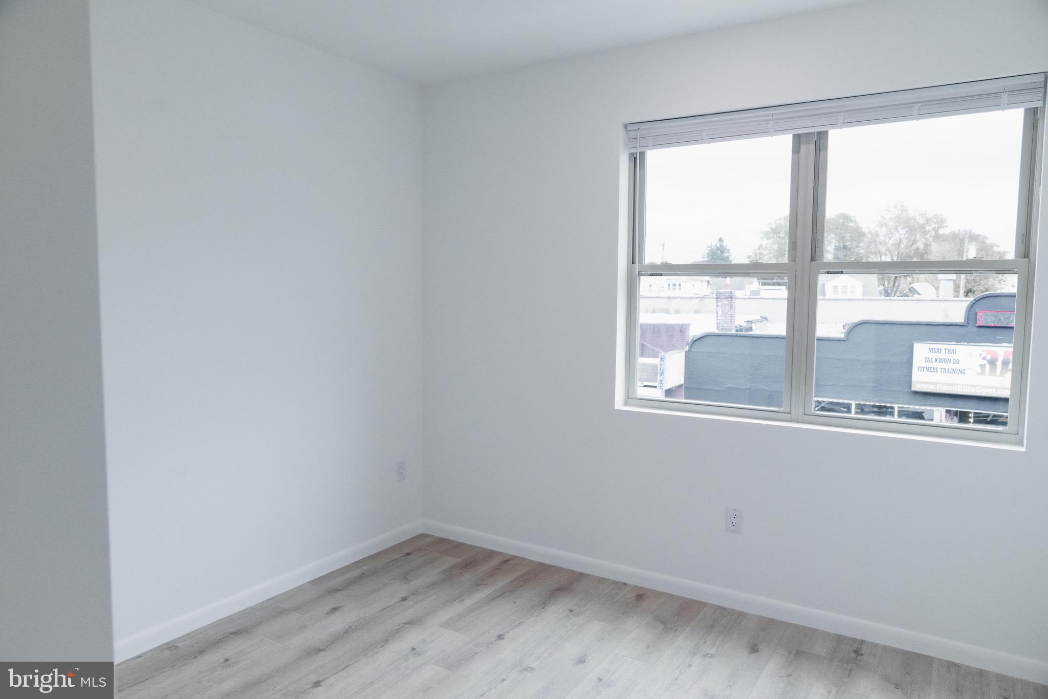 7248 Rising Sun Avenue, Unit 201 Philadelphia, PA 19111 - Photo 12 of 20 an empty room with wooden floor and windows