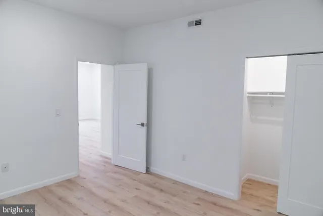 a view of an empty room with wooden floor