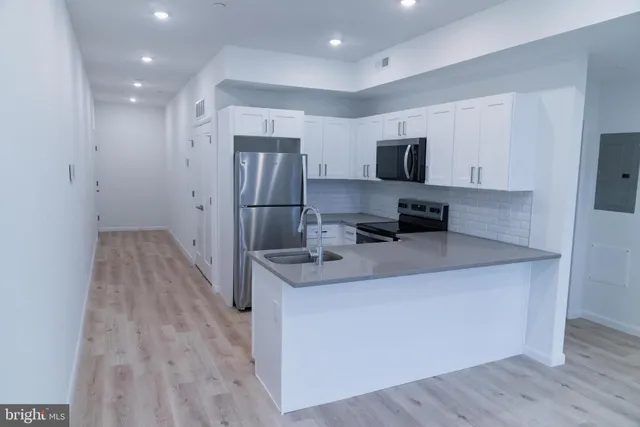 a kitchen with stainless steel appliances a refrigerator and a stove top oven