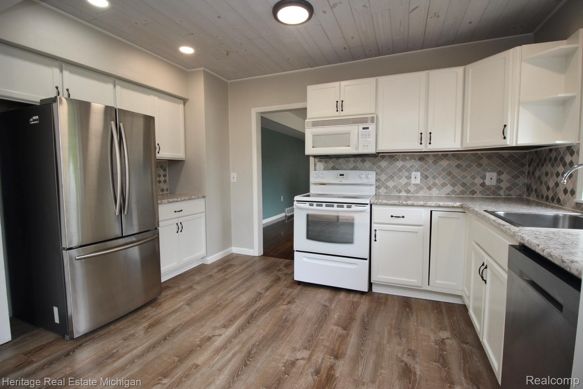 15352 South Duffield Road Byron, MI 48418 - Photo 6 of 47 Kitchen featuring white cabinetry, wood-finish flooring, recessed lighting, and a decorative tile backsplash