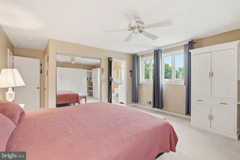 a bedroom with a large bed and chandelier fan