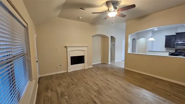 a view of an empty room with a fireplace and a window