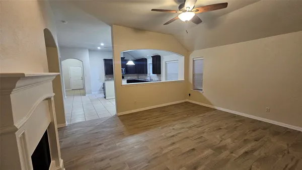 a view of a livingroom with wooden floor and a ceiling fan
