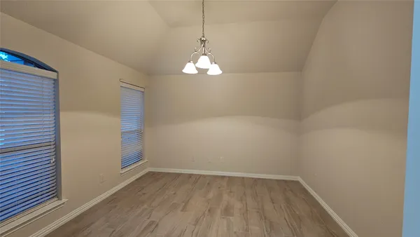 a view of a room with wooden floor and a window