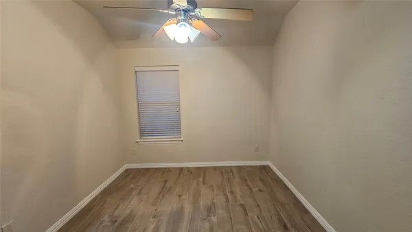 a view of room with a ceiling fan and wooden floor