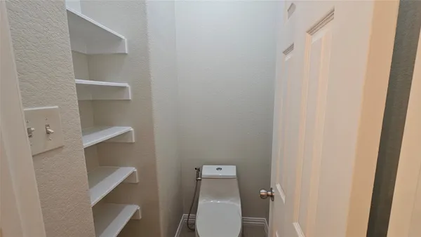 a white toilet sitting next to a white cabinet