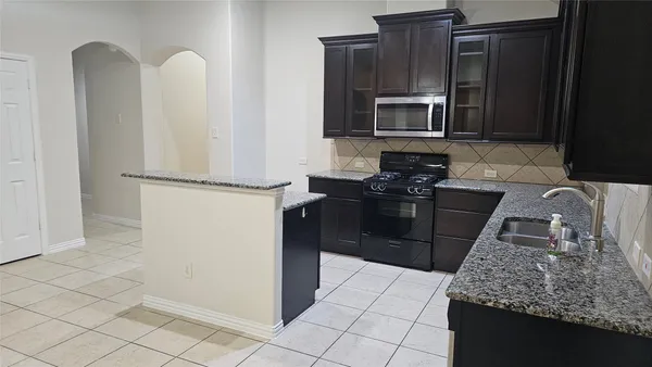 a kitchen with stainless steel appliances granite countertop a refrigerator stove and microwave