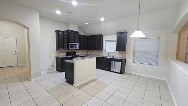 a kitchen with stainless steel appliances granite countertop a refrigerator and a sink