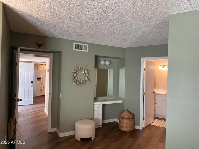 a view of a hallway with wooden floor and a bathroom