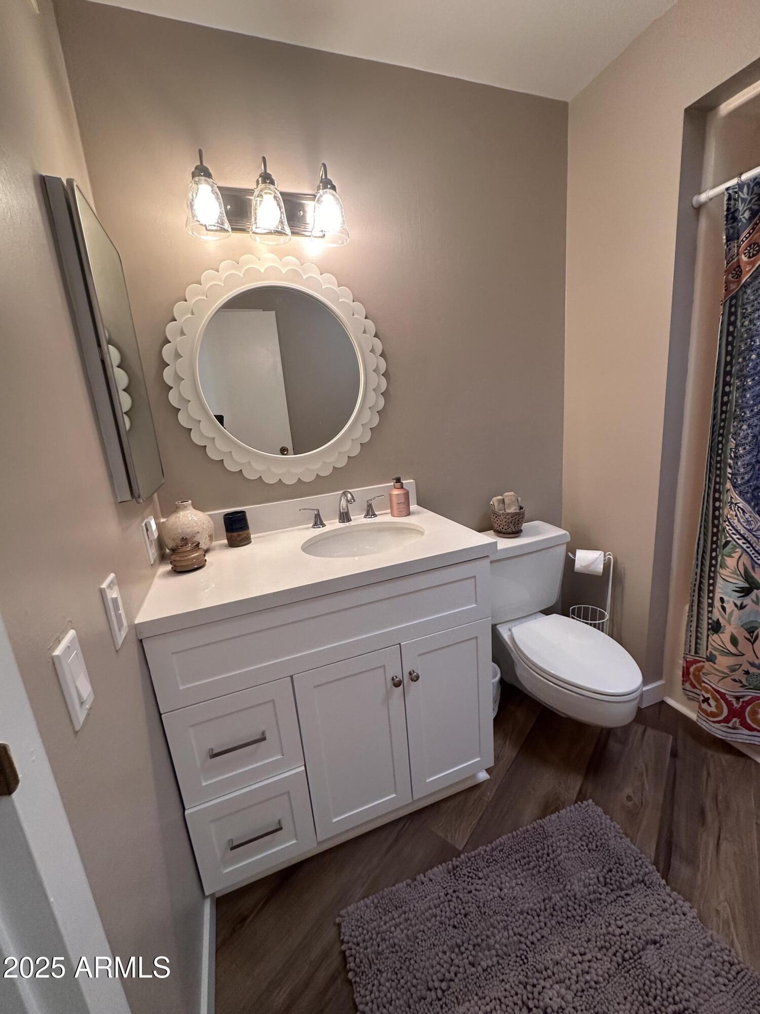 17247 North 106th Avenue Sun City, AZ 85373 - Photo 17 of 30 a bathroom with a toilet a sink and mirror