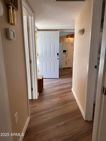 a view of a hallway with wooden floor and closet