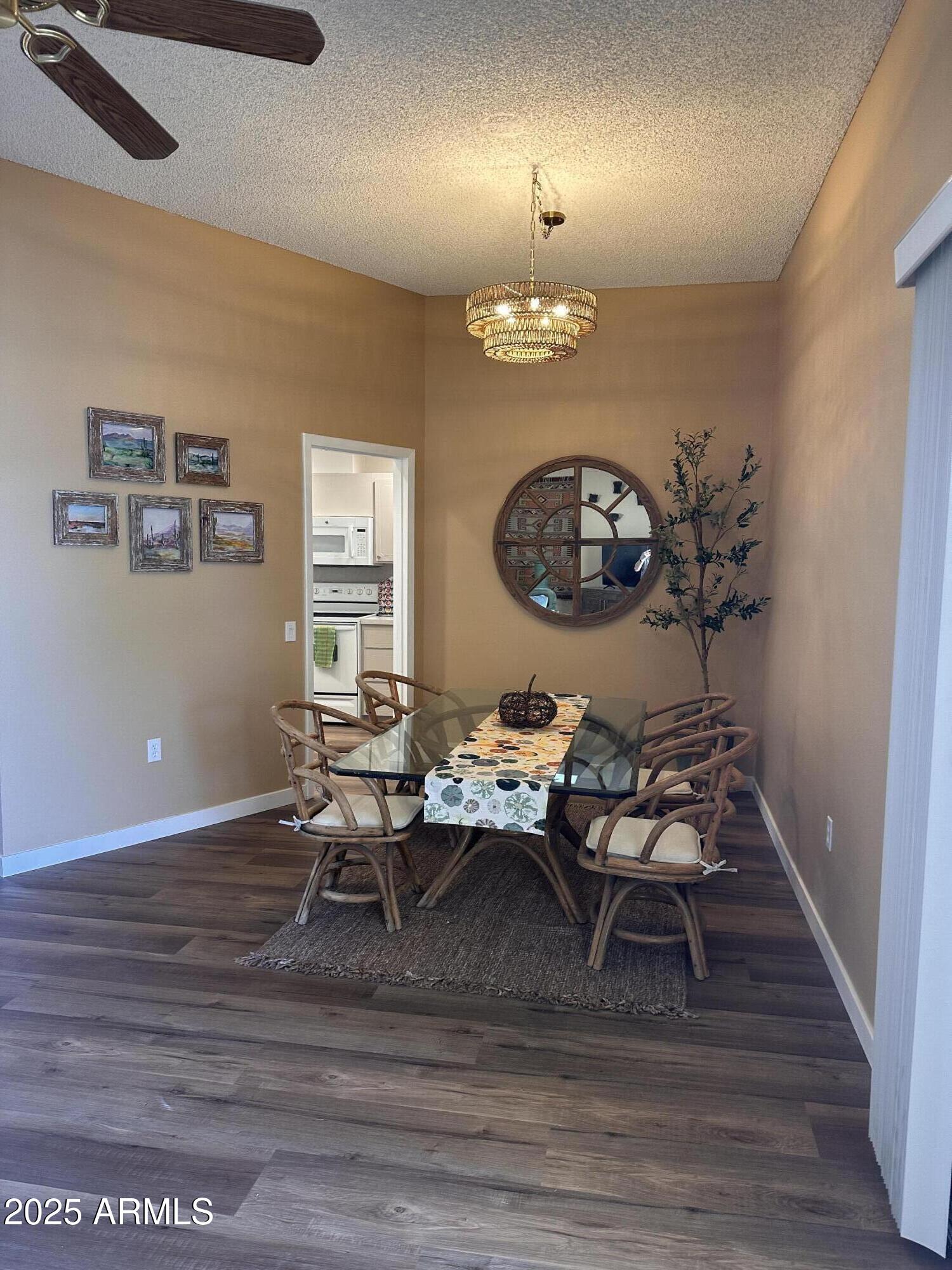17247 North 106th Avenue Sun City, AZ 85373 - Photo 4 of 30 a living room with furniture a chandelier and a wooden floor